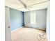 Simple bedroom with blue accent wall, carpet flooring, and a window allowing natural light at 901 N Van Wert N Rd, Villa Rica, GA 30180