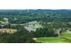 Overhead view showcasing the golf course with a lake and lush green fairways surrounded by trees and homes at 921 Sundown Pt, Villa Rica, GA 30180