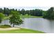 A golf course featuring lush greenery, a tranquil lake, and a serene sand trap at 921 Sundown Pt, Villa Rica, GA 30180