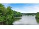 Tranquil view of a calm lake surrounded by lush green trees and a clear sky at 921 Sundown Pt, Villa Rica, GA 30180