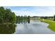 Scenic view of a tranquil pond with new homes in the background of a green golf course community at 921 Sundown Pt, Villa Rica, GA 30180