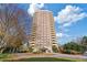 A striking view of the high-rise condo building surrounded by lush landscaping and blue skies at 1501 Clairmont Rd # 1731, Decatur, GA 30033
