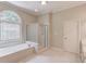 Bathroom features separate shower and tub with mosaic-style window at 2748 Hidden Falls Dr, Buford, GA 30519