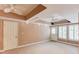Spacious bedroom with tray ceiling, ceiling fans, and shuttered windows at 2748 Hidden Falls Dr, Buford, GA 30519