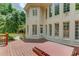 Expansive back of house view with plentiful windows, a wooden deck and a relaxing hot tub at 2748 Hidden Falls Dr, Buford, GA 30519