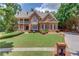Beautiful two-story brick home with manicured lawn and covered front porch at 2748 Hidden Falls Dr, Buford, GA 30519