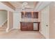 Open living room features a wet bar with custom cabinets, mini-fridge, and a ceiling fan at 2748 Hidden Falls Dr, Buford, GA 30519