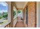 Charming porch with brick walls, wooden floor, and a view of the street at 2748 Hidden Falls Dr, Buford, GA 30519