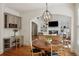 Open concept dining room with hardwood floors and large chandelier adjacent to living room at 5059 Belair Bluff Se Ct, Smyrna, GA 30126