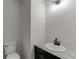 Neat half-bathroom features a toilet and a sink with a granite countertop at 1373 W Prospect Dr, Lawrenceville, GA 30043