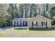 Charming single-story home with blue door, dark shutters, and a well-maintained front lawn surrounded by trees at 1373 W Prospect Dr, Lawrenceville, GA 30043