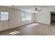 Bright living room features a doorway to the exterior, hardwood flooring and a ceiling fan at 1373 W Prospect Dr, Lawrenceville, GA 30043