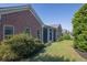 Exterior view shows a brick home with lush landscaping, a well-maintained lawn, and screened porch at 1550 Rolling View Dr, Cumming, GA 30040