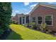 Brick home exterior featuring well-maintained lawn, lush landscaping, and screened porch at 1550 Rolling View Dr, Cumming, GA 30040