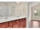 Bathroom features a double sink vanity with cherry wood cabinets at 1550 Rolling View Dr, Cumming, GA 30040