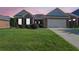 Charming brick home with a well-manicured lawn and two-car garage under a sky painted with hues of pink and orange at twilight at 1550 Rolling View Dr, Cumming, GA 30040