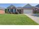 Charming brick home with a well-manicured lawn and two-car garage under a clear blue sky at 1550 Rolling View Dr, Cumming, GA 30040