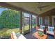 Relaxing screened porch with brick accent wall, ceiling fan, and cozy patio furniture at 1550 Rolling View Dr, Cumming, GA 30040