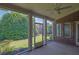 Relaxing screened porch with brick accent wall and ceiling fan overlooks lush backyard at 1550 Rolling View Dr, Cumming, GA 30040