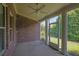 This screened porch with brick accent wall and ceiling fan connects indoor-outdoor living at 1550 Rolling View Dr, Cumming, GA 30040