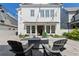 Inviting backyard patio with stone pavers, outdoor string lights, comfortable seating, and manicured landscaping at 6820 Colfax Ave, Cumming, GA 30040