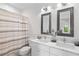 Bright bathroom featuring dual vanity with marble countertop and framed mirrors at 6820 Colfax Ave, Cumming, GA 30040