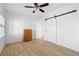 Empty bedroom featuring hardwood floors, ceiling fan, and a barn door at 6820 Colfax Ave, Cumming, GA 30040