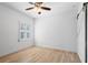 Empty bedroom featuring hardwood floors, ceiling fan, and a barn door at 6820 Colfax Ave, Cumming, GA 30040