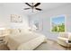 Bright bedroom featuring hardwood floors, ceiling fan, and large windows with shutter blinds at 6820 Colfax Ave, Cumming, GA 30040
