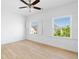 Bright bedroom featuring hardwood floors, ceiling fan, two windows with shutter blinds at 6820 Colfax Ave, Cumming, GA 30040