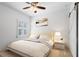 Cozy bedroom features a ceiling fan, plush bedding, and a charming barn door, offering comfort and style at 6820 Colfax Ave, Cumming, GA 30040