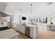 Open-concept kitchen featuring a marble island, stainless steel appliances, and a seamless flow into the living area at 6820 Colfax Ave, Cumming, GA 30040
