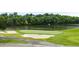 Aerial view of a green and pristine golf course with sand traps and lake at 910 Sundown Pt, Villa Rica, GA 30180