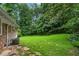 Private backyard featuring a green lawn, trees, and a small patio at 2775 Belleau Se Ln, Atlanta, GA 30316
