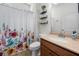 Cozy bathroom with a floral shower curtain and decorative shelving at 5318 Burrus Ln, Mableton, GA 30126