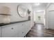Inviting entryway with a modern storage unit, mirror, hardwood floors, and bright lighting at 5318 Burrus Ln, Mableton, GA 30126