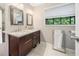 Bathroom features double sink vanity, a towel rack, and a large window at 162 Nouveau Sw Ct, Lilburn, GA 30047