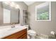 Powder room featuring a vanity sink, a mirror and a window at 162 Nouveau Sw Ct, Lilburn, GA 30047