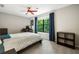 Bedroom with a large window providing natural light, neutral-toned walls and ceiling fan at 162 Nouveau Sw Ct, Lilburn, GA 30047