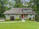 Inviting two-story home with well-maintained lawn, mature landscaping, and a striking red front door at 162 Nouveau Sw Ct, Lilburn, GA 30047