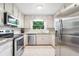 Kitchen features stainless appliances, white cabinets, and a subway tile backsplash at 162 Nouveau Sw Ct, Lilburn, GA 30047