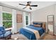 Bright bedroom with ceiling fan, large windows, comfortable blue bedding and accent furniture at 290 Prescott Dr, Acworth, GA 30101