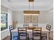 A bright dining room with a white table, black chairs, modern light fixture, and decorative wall art at 290 Prescott Dr, Acworth, GA 30101