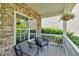 Relaxing front porch featuring stone facade, outdoor seating, and hanging plants, creating a welcoming entrance at 290 Prescott Dr, Acworth, GA 30101
