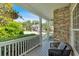Inviting front porch adorned with stone detailing, a comfortable chair, and vibrant greenery, offering a serene outdoor space at 290 Prescott Dr, Acworth, GA 30101