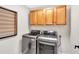 Modern laundry room featuring a front-load washer and dryer with wooden cabinets at 290 Prescott Dr, Acworth, GA 30101