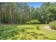 Lush backyard bordered by a wooden fence, featuring a swing set and mature trees at 412 Gray Fox Dr, Canton, GA 30114