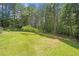 Large, grassy backyard surrounded by mature trees, ideal for outdoor activities at 412 Gray Fox Dr, Canton, GA 30114