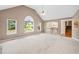 Spacious living room featuring vaulted ceiling, neutral carpet, and large windows that fill the space with light at 412 Gray Fox Dr, Canton, GA 30114
