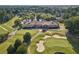 Aerial view of a golf course with beautiful clubhouse, bunkers, and tree-lined fairways at 6455 Darely Ct, Cumming, GA 30040